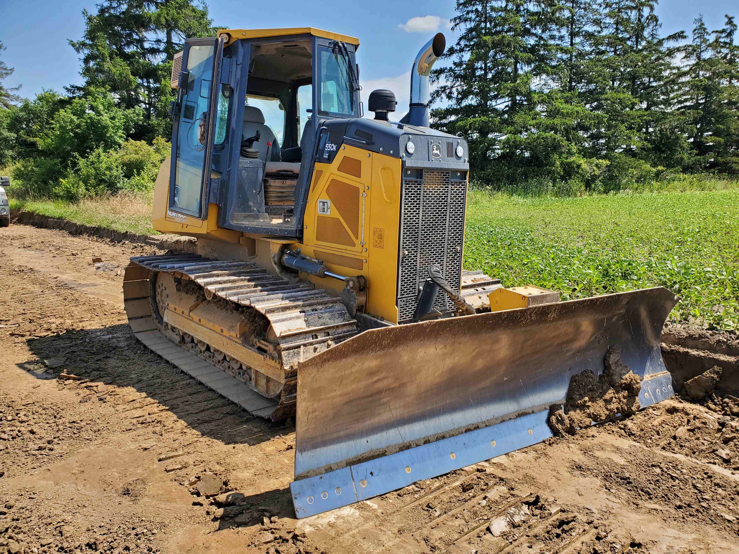 Deere 550K LGP dozer working on custom road building in Haldimand