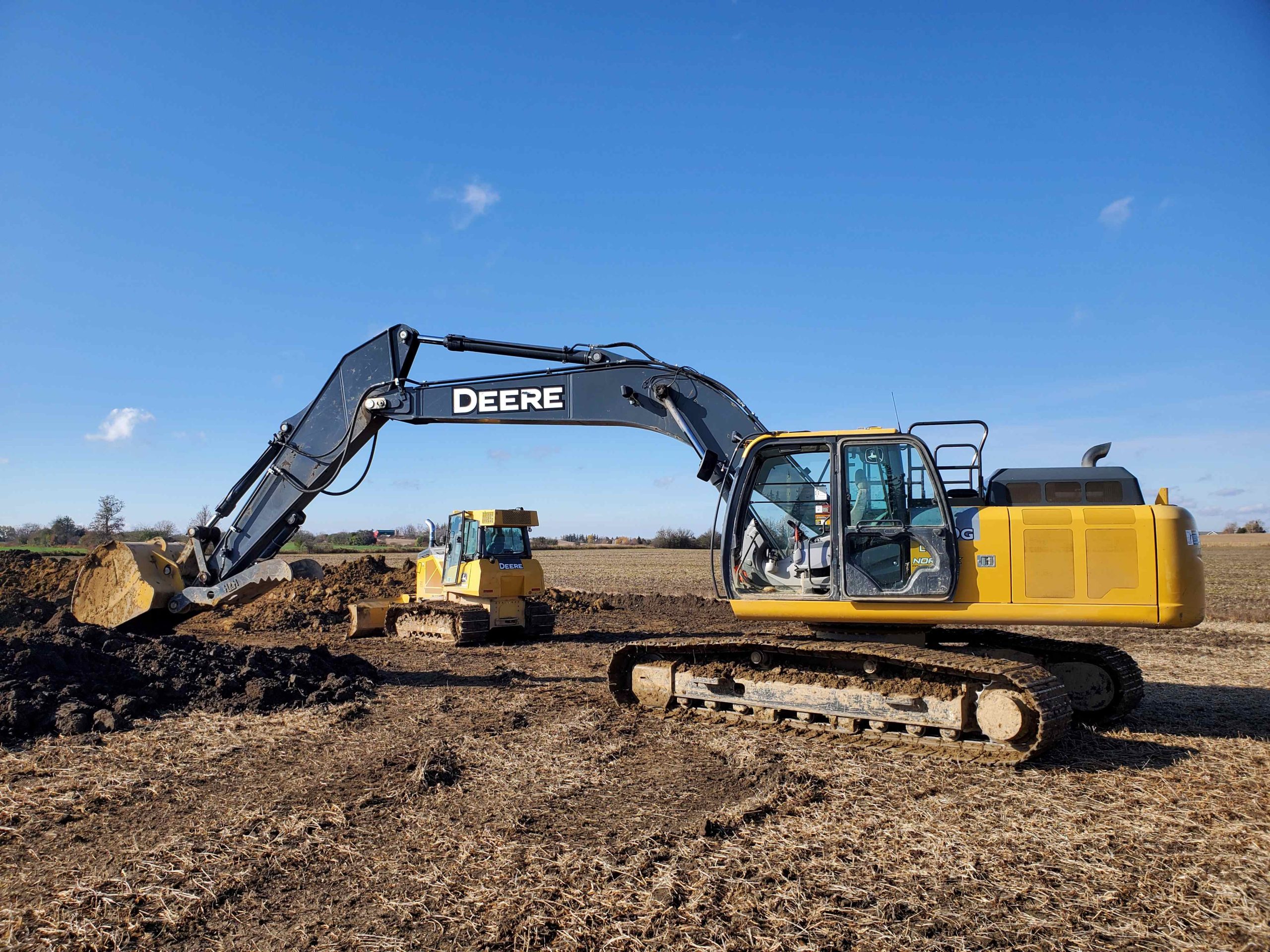 Deere 250G excavator and Deere 550K LGP dozer working together in Hamilton for road building and land clearing