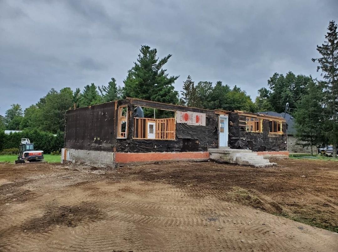 Partial house demolition and lot clearing in Waterdown, with brick façade, attached garage, and roof removed